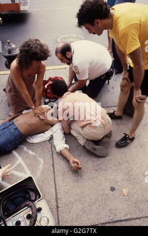 Passanten und Sanitäter führen Sie Herz-Lungen-Wiederbelebung (HLW) auf eine Fußgängerzone Schuss Pistole auf St. Marks und Third Avenue, Stockfoto