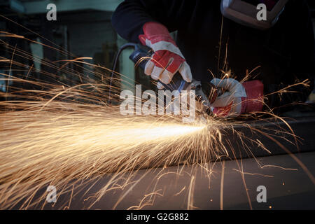 Nahaufnahme mit Schutzhandschuhe und Funken Schleifen Stockfoto