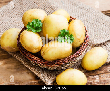 Junge Kartoffeln in einem Korb mit grüner Petersilie Blätter Stockfoto