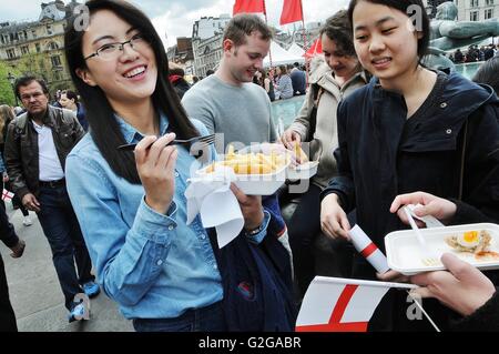 Ein chinesisches Mädchen genießt Fish &amp; Chips am St.-Georgs-Tag, Trafalgar Square in London. Stockfoto