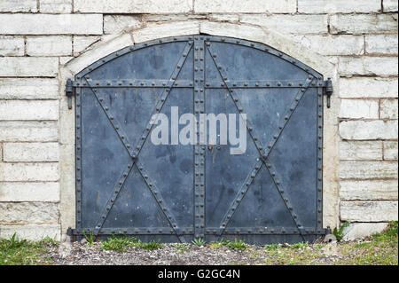 Geschlossenen blauen Metalltor in alten Steinmauer Stockfoto