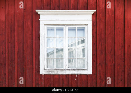 Alte rote Holzwand mit Fenster in weißer Rahmen, typisch skandinavisch Leben Haus Architektur Detail Stockfoto