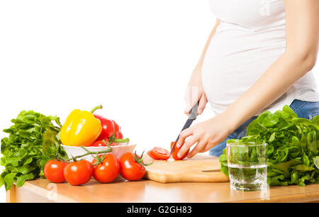 Nahaufnahme der schwangeren Frau schneiden Tomate Stockfoto