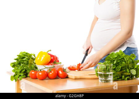 Nahaufnahme der schwangeren Frau schneiden Tomate Stockfoto