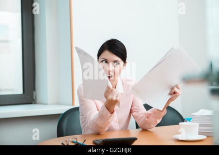 Frau im Büro mit zerknittertes Papier. Stockfoto