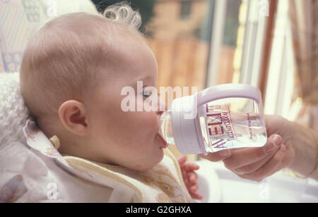 Mutter, Baby mit Down-Syndrom-Flasche Wasser Stockfoto