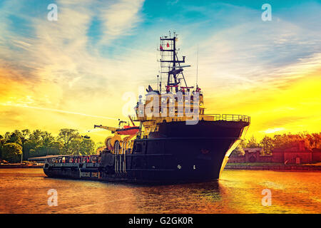 Schlepper bei Sonnenaufgang zum Hafen kommen. Stockfoto