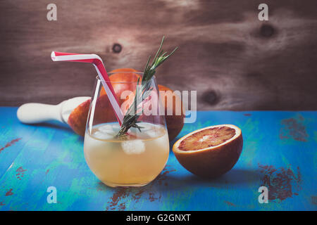 Frisch gepressten Saft und Blutorangen auf blauem Hintergrund, Tequila Palomas mit Rosmarin, Sommer-Getränk Stockfoto