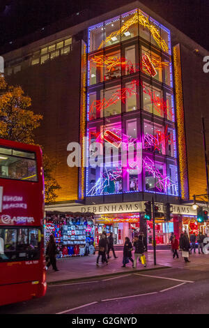 Leute, die an Weihnachten an Debenhams Kaufhaus in der Oxford Street vorbeigingen, das mit Weihnachtslichtern in London, Großbritannien, dekoriert wurde Stockfoto