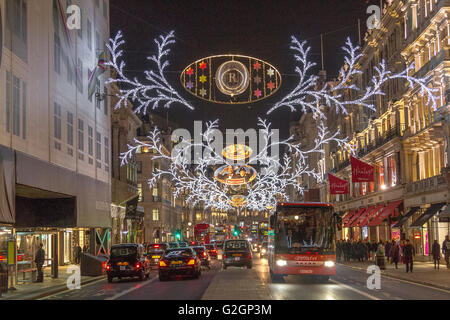 Weihnachtslichter entlang einer geschäftigen Regent Street, die zur Weihnachtszeit im West End von London voller Einkaufsbummel ist Stockfoto