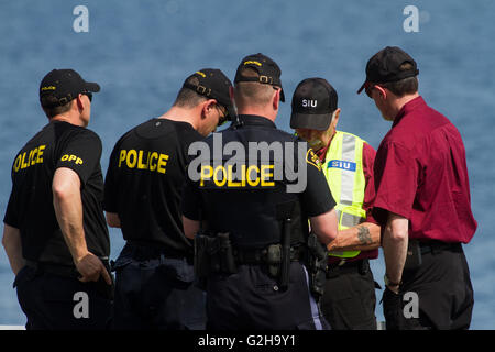 Ermittler aus speziellen Untersuchungen Maßeinheit sprechen OPP Offiziere bei einem Fahrzeuganprall in Amherstview, Ontario, am 27. Mai 2016. Stockfoto