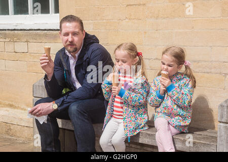 Oakham, Rutland, England, UK., 30. Mai 2016. Oakham Castle wurde wiedereröffnet, nachdem £2 m Wert von Restaurierungsarbeiten abgeschlossen wurde, das Geld von der Heritage Lottery Fund zur Verfügung gestellt. Zur Feier der Wiedereröffnung fanden viele Norman-Themen-Events im Schlosspark einschließlich Münze auffällig, Bogenschießen, die Herstellung von Kettenhemden und vieles mehr statt. Vater und seinen beiden Töchtern, genießen Sie eine kühlere Eis Credit: Jim Harrison/Alamy Live News Stockfoto