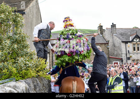 Castleton, Derbyshire, UK. 30. Mai 2016. Alten Garland Zeremonie obwohl die Straßen von Castleton im Peak District. Die Girlande "selbst ist ein Bienenstock förmigen Kopf-Kleid, mit Wildblumen und grün, die vom König über seinen Kopf und Schultern getragen wird. Die oberste, abnehmbare Stück die Girlande ist bekannt als "The Queen" und ist auch ein kleiner Bienenkorb-Form. Der Kranz oft wiegt zwischen 50 und 60 Pfund und ist sehr schwer, auf des Königs Schultern zu tragen. Bildnachweis: Ian Francis/Alamy Live-Nachrichten Stockfoto