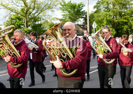 Castleton, Derbyshire, UK. 30. Mai 2016. Alten Garland Zeremonie obwohl die Straßen von Castleton im Peak District. Die Girlande "selbst ist ein Bienenstock förmigen Kopf-Kleid, mit Wildblumen und grün, die vom König über seinen Kopf und Schultern getragen wird. Die oberste, abnehmbare Stück die Girlande ist bekannt als "The Queen" und ist auch ein kleiner Bienenkorb-Form. Der Kranz oft wiegt zwischen 50 und 60 Pfund und ist sehr schwer, auf des Königs Schultern zu tragen. Der König und seine Gemahlin sind Stuart Kostüm gekleidet. Castleton Blaskapelle. Bildnachweis: Ian Francis/Alamy Live-Nachrichten Stockfoto