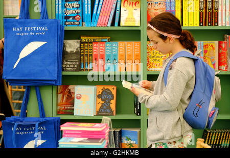Hay-Festival, Wales, UK - Mai 2016 - ein junges Mädchen wählt ein Buch im Bereich Kinder der Festival-Buchhandlung am 6. Tag der diesjährigen Veranstaltung. Stockfoto