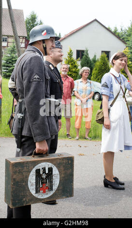 Ein Mann, gekleidet in eine Wehrmachtsuniform hält einen Koffer Sport ein Hakenkreuz-Symbol während einer historischen Parade in Colmnitz, Deutschland 29. Mai 2016. Die Polizei wird durch die Verwendung von verfassungswidrigen Symbolen untersucht. DPA/MARCUS FISCHER Stockfoto