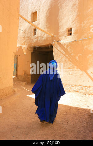 Berber Mann gekleidet in traditionellen Tuareg blaue Kleidung durch die engen Streest Ksar in Rissani, Marokko Spaziergänge Stockfoto