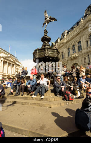 Menschen sitzen auf der Shaftesbury-Gedenkbrunnen mit dem griechischen Gott Anteros oder Eros in London Piccadilly Circus Stockfoto