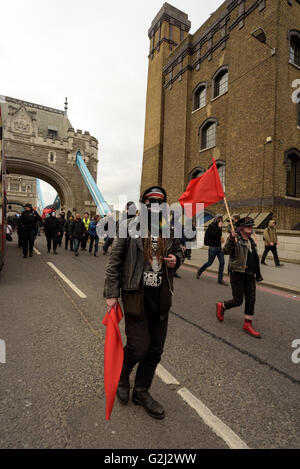 May Day anarchistische Gruppe, mit versteckten Gesichtern, Parolen und roten Fahnen zu Fuß über die Tower Bridge 1. Mai 2016 Stockfoto