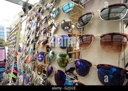 Verschiedene touristische Sonnenbrillen auf dem Display an einem Marktstand in Brick Lane London Stockfoto