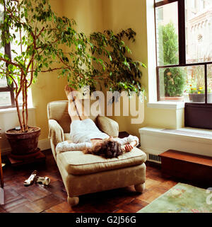 Frau auf Chaise Lounge entspannen Stockfoto
