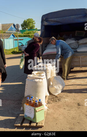 Mann im Gespräch mit Kunden an seinem Marktstand Hühnerfutter in Russland während Mai 2016 Stockfoto