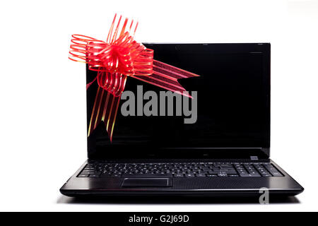 Schwarzer Laptop mit roten Schleife Geschenk isoliert auf weiss Stockfoto