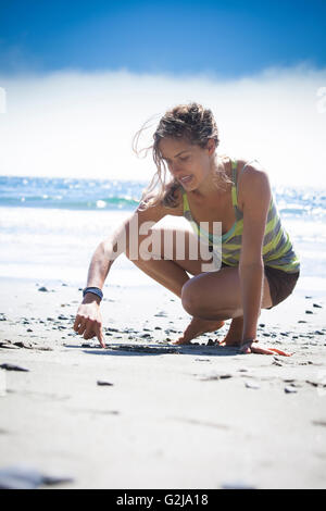 Eine junge Frau zieht den Finger im Sand am China Tagesgebühr Strandbereich in Juan de Fuca Provincal Park Vancouver Island BC Kanada Stockfoto