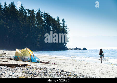 Eine junge Frau geht barfuß am Strand am französischen Beach Provincial Park entlang. Vancouver Island, BC, Kanada. Stockfoto