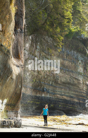 Eine junge stehend mit Wasserfall im Mystic Beach entlang der Juan de Fuca Trail. Vancouver Island, BC, Kanada. Stockfoto