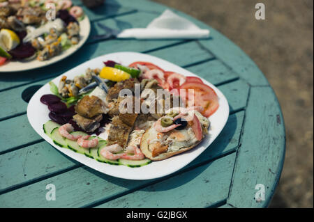 Ein Sortiment von Krabben, Muscheln und Fisch auf einem Teller außerhalb Stockfoto