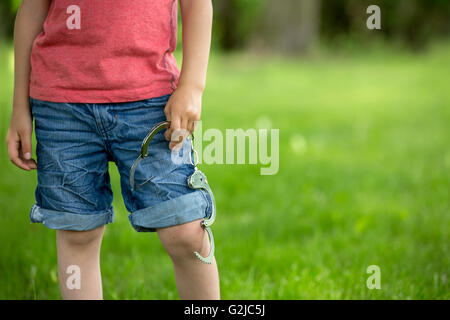 Niedliche kleine Junge mit Handschellen an den Händen, spielen Stockfoto