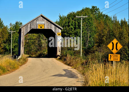 Eine hölzerne einspurige überdachte Brücke, erbaut 1910 überspannt einen Stream auf einer zweispurigen Straße Plumweseep im ländlichen New Brunswick, Kanada Stockfoto