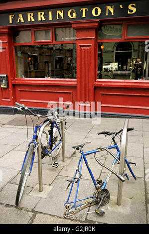 Zwei Fahrräder, eins mit fehlenden Räder geparkt vor Farringtons Pub in Dublin, Temple Bar-Bereich, Irland Stockfoto