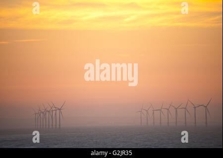 Windkraftanlagen in Redcar Beach produzieren erneuerbare Bioenergie im Meer bei Sonnenuntergang Stockfoto