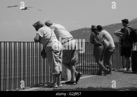 Paar genießt die Aussicht auf das Meer, stützte sich auf Geländer mit Blick auf Seevögel Overhead Möwen schwarz-weiß auf Urlaub einweichen Stockfoto