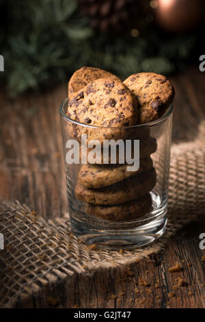 Frisch gebackene Schokoladenkekse in einem Glas auf einem rustikalen Holztisch. Stockfoto
