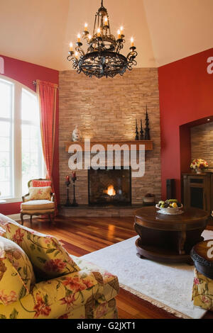 Blumige gepolstertes Sofa Wohnzimmerstühle beleuchtet Gas-Kamin im