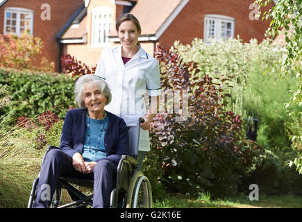 Porträt der Pflegeperson Senior Frau im Rollstuhl schieben Stockfoto