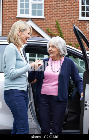 Weibliche Nachbarn geben Senior Woman A Lift im Auto Stockfoto