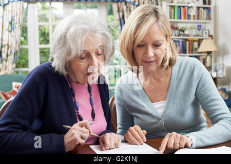 Weibliche Nachbarn helfen Senior Frau Formular ausfüllen Stockfoto