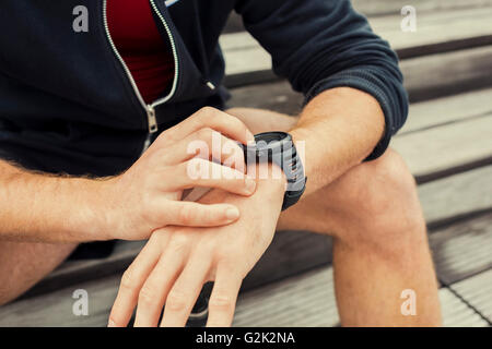 Städtischen Jogger Prüfung an Herzfrequenz-Monitor Smartwatch nach dem Training Stockfoto