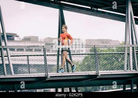 Laufenden männlich Joggen auf grafische Metallbrücke Stockfoto