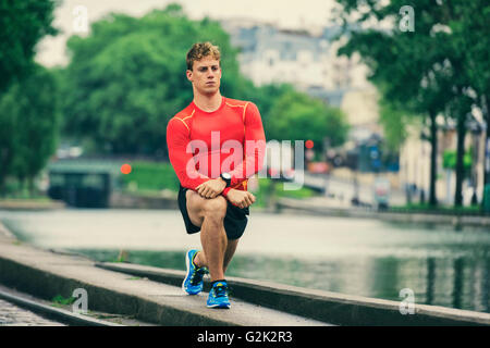 Junger sportlicher Mann Strecken außerhalb Stockfoto