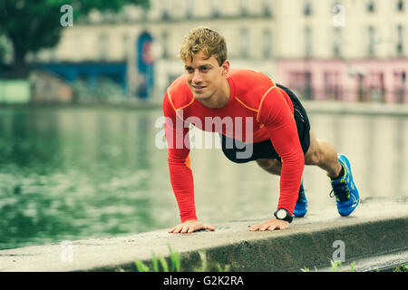 Junge Mann tut Push Ups. Bewegung in der Natur. Stockfoto