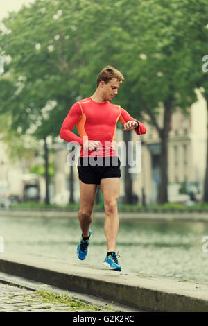 Läuft Man Blick auf seine Herzfrequenz-Monitor smart Sportuhr beim Training training Stockfoto