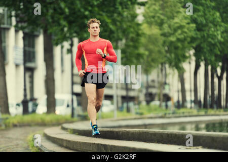 Junge Menschen in der Stadt laufen. Kaukasische Cheerfull Jogger männlich in seinen 20ern Stockfoto