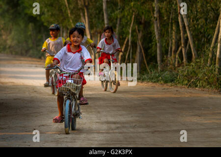 Vielfalt: vietnamesische Kinder genießen Reiten Fahrräder auf einem Feldweg im Frühjahr, TraSu Nature Reserve, Chau Doc, Mekong Delta, Vietnam Stockfoto