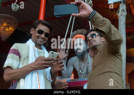 Zwei Männer schießen Selfie mit Naga Sadhu auf Sling In Akhara, Ujjain Kumbh Mela 2016 Stockfoto