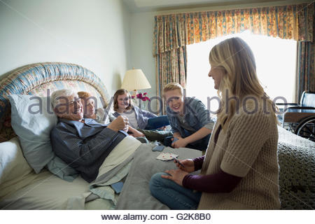 Generationsübergreifende Familie Spielkarten mit Altern Großvater im Bett
